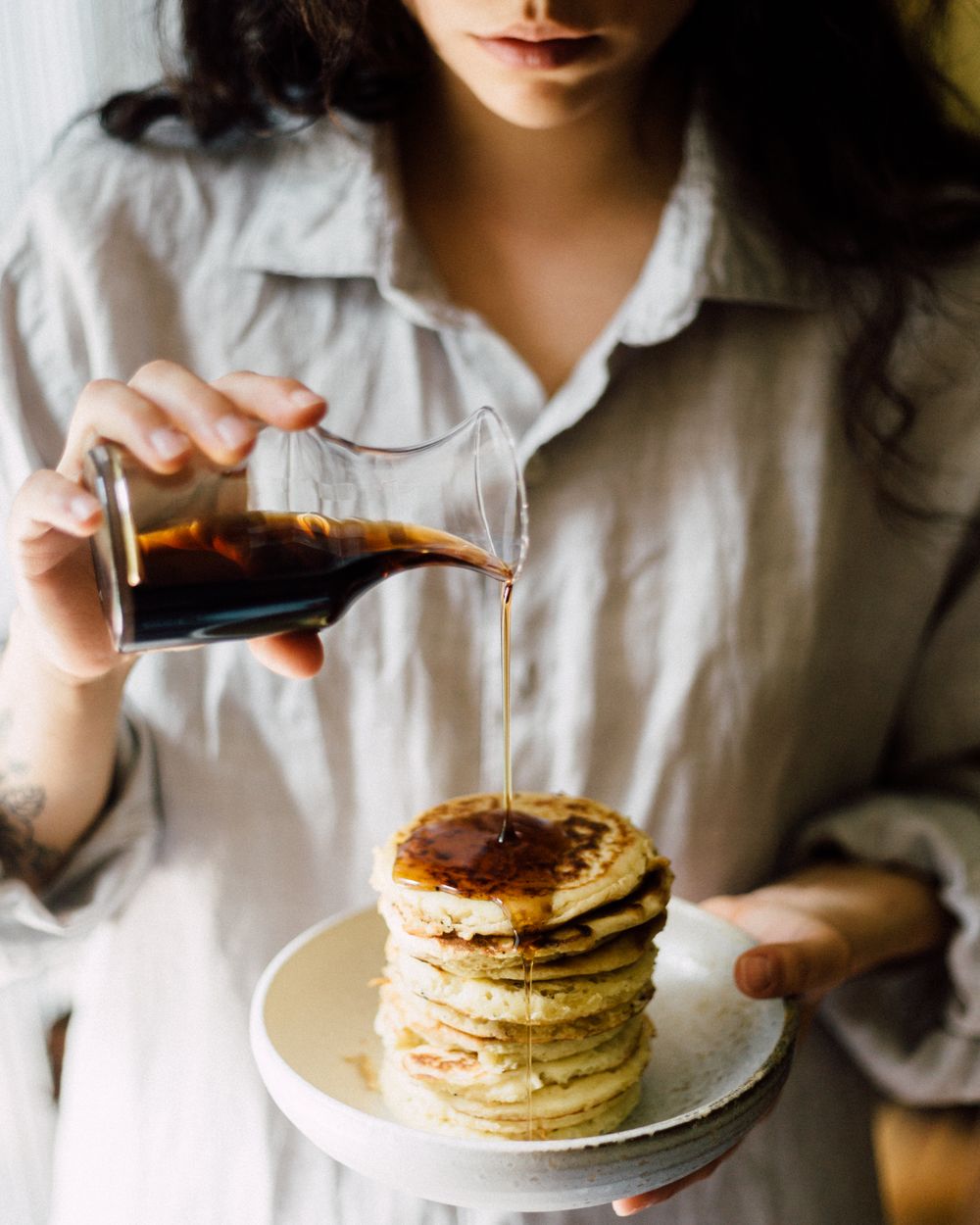 Maple syrup poured over a fresh stack of Oat-EH oat pancakes